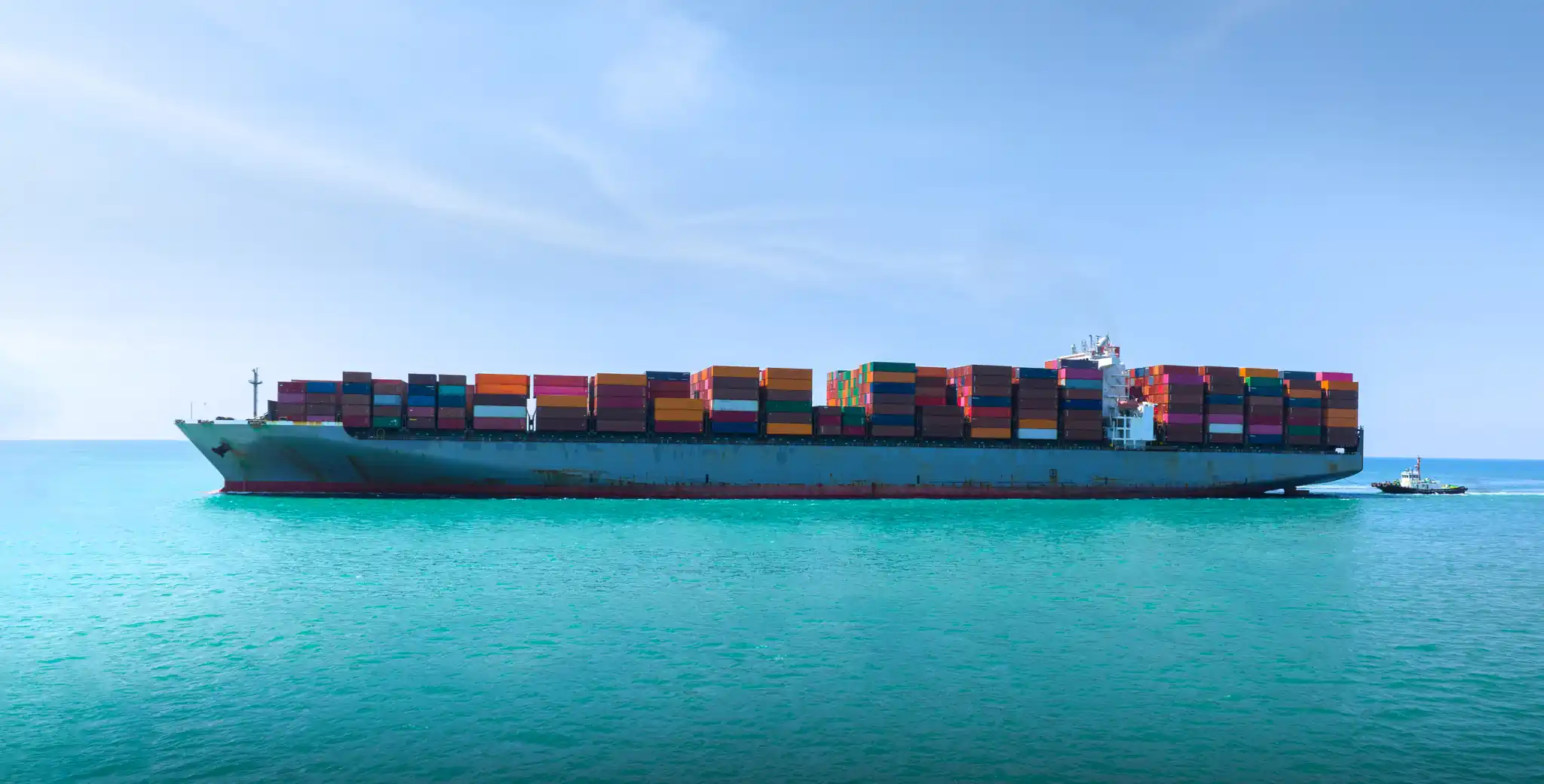 Cargo ship sailing on turquoise blue water